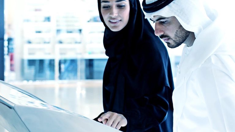 Arab family using interactive screen of digital kiosk - stock photo