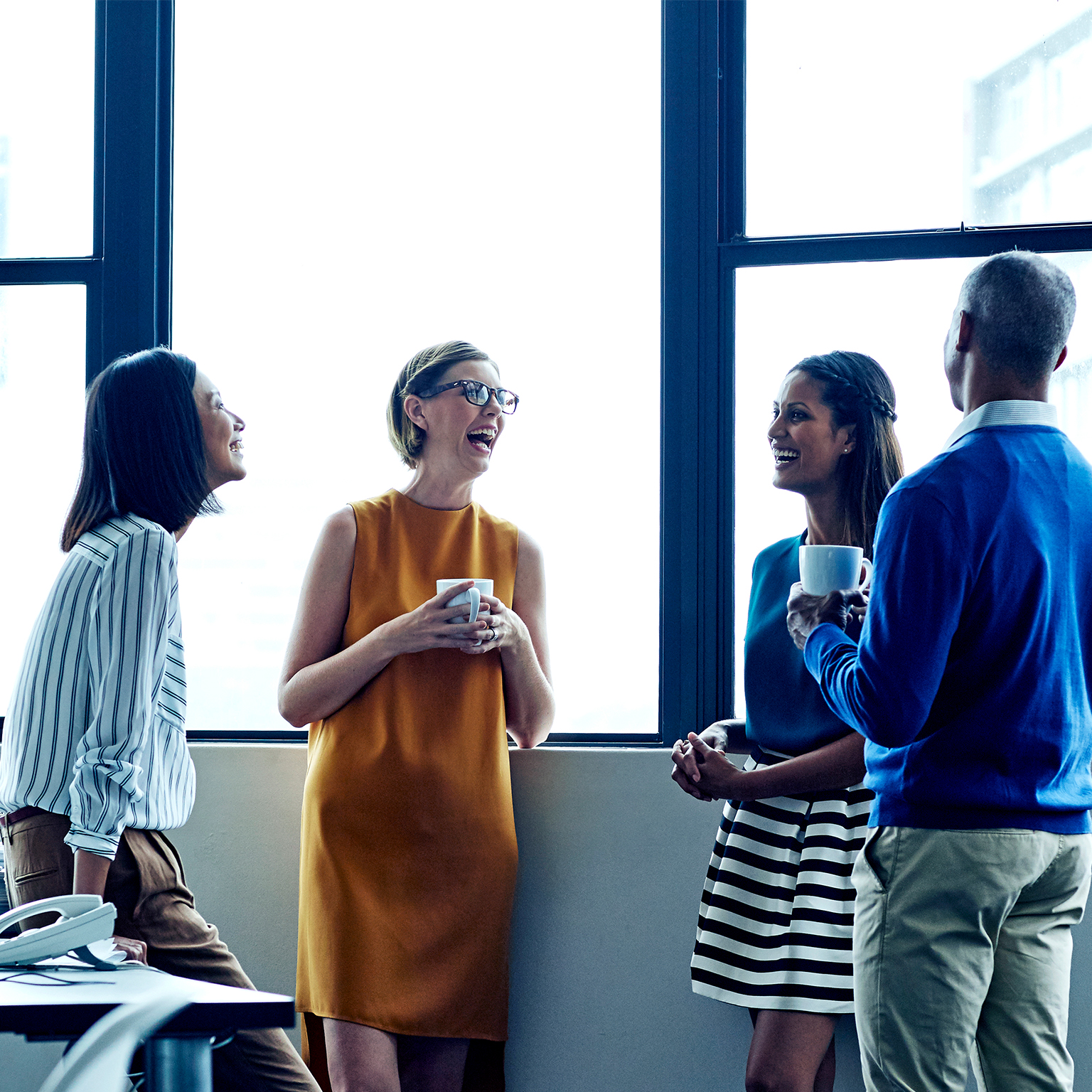 Four employees having a casual chat in office