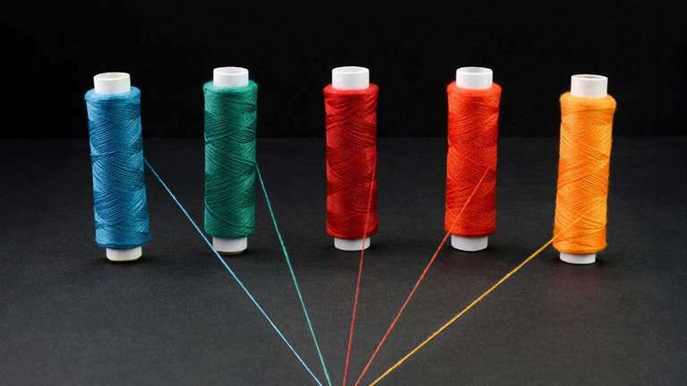 Multicolored spools of strings attached together, - stock photo