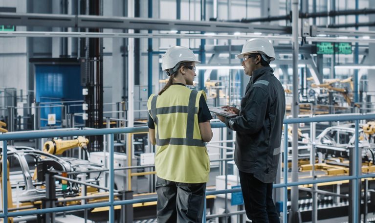 Two workers talking in a factory
