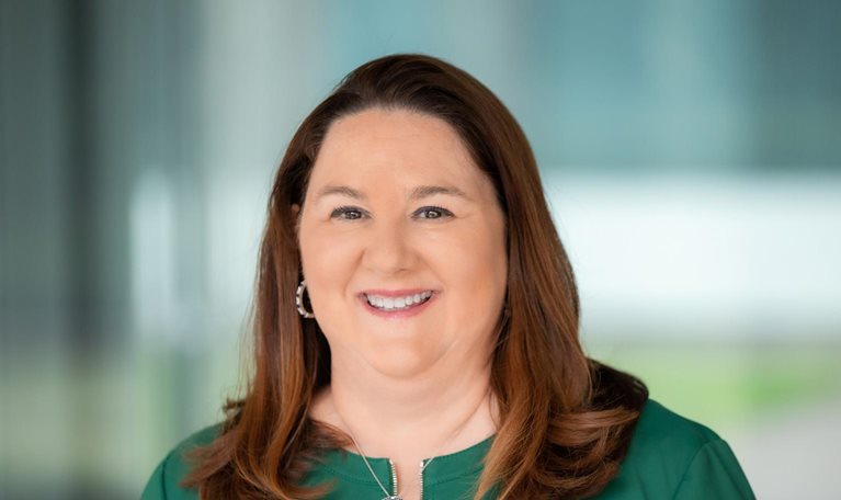 Lisa Blair Davis wearing a green business jacket and a smile on her face.