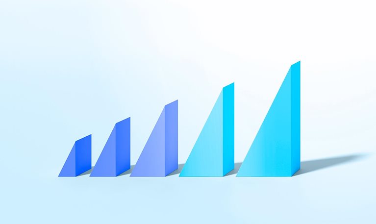 Colorful triangle shapes on pastel background increasing in size to illustrate growth