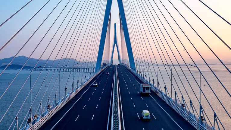 Aerial view of a bridge across a bay at sunset.
