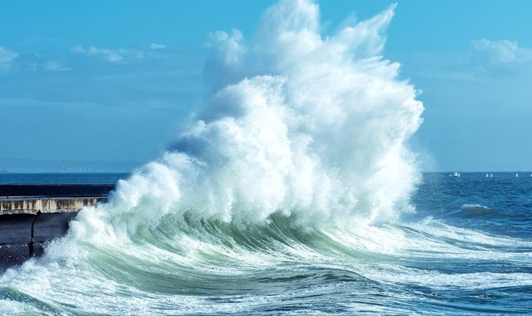 Big waves breaking against a seawall on the coast