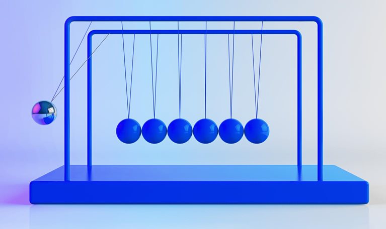 Newton's Cradle, with shiny, metallic balancing balls. Six remain still as one is in motion.