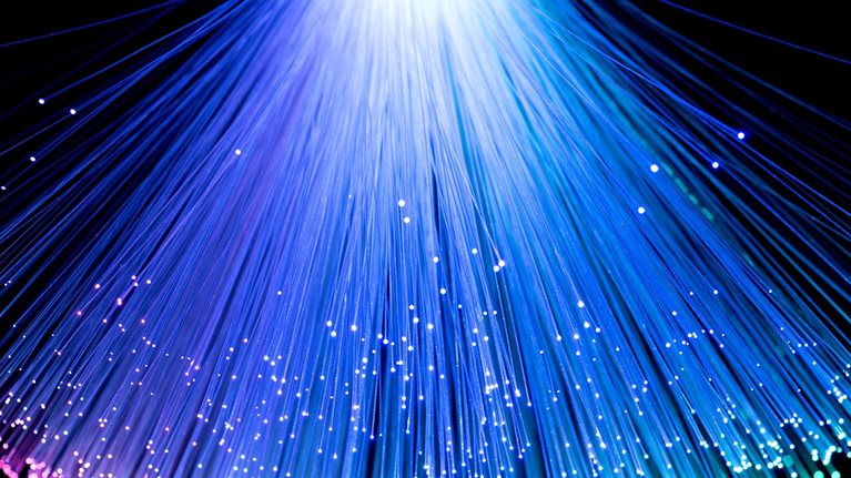 Multi-colored converging fan shape fiber optics on black background.