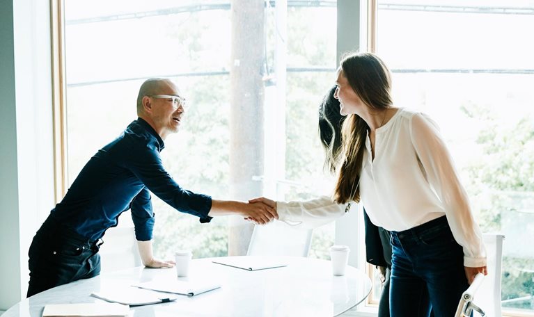 Businesswoman shaking hands with client before meeting