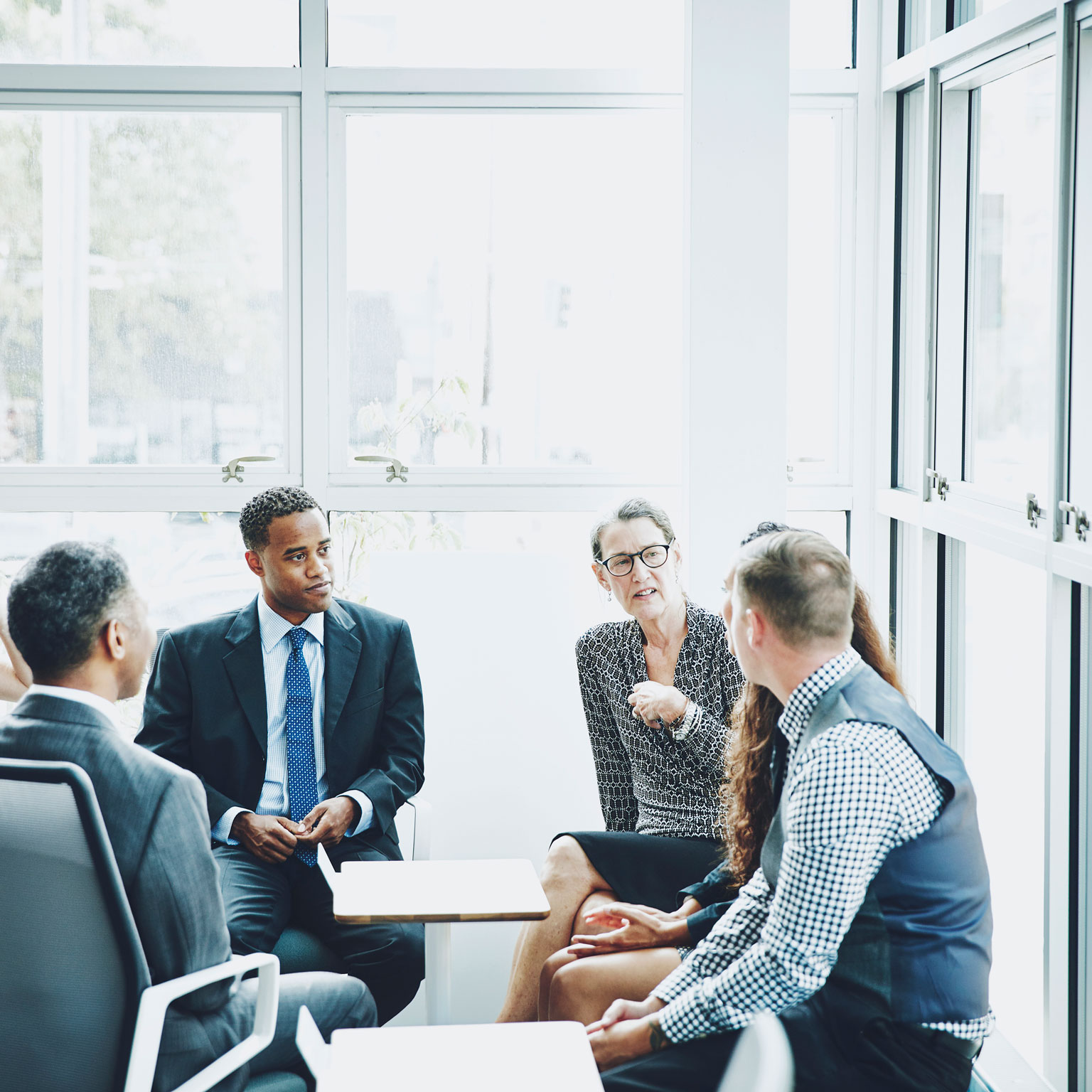 Overview of a group of C-Suite business leaders having a discussion.