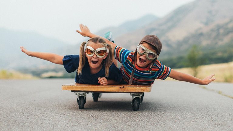 Young Kids Flying on a Press Cart - stock photo