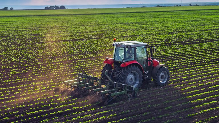 Tractor cultivating field at spring