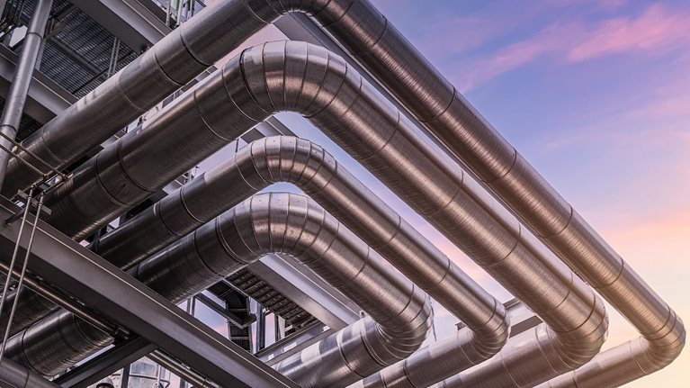 Steel pipelines and valves at at oil-refinery plant and sky - stock photo