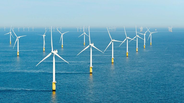 Windmills standing in a waterbody.