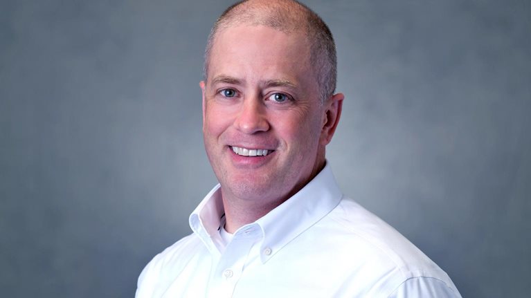 Andrew Rose in white shirt with gray background