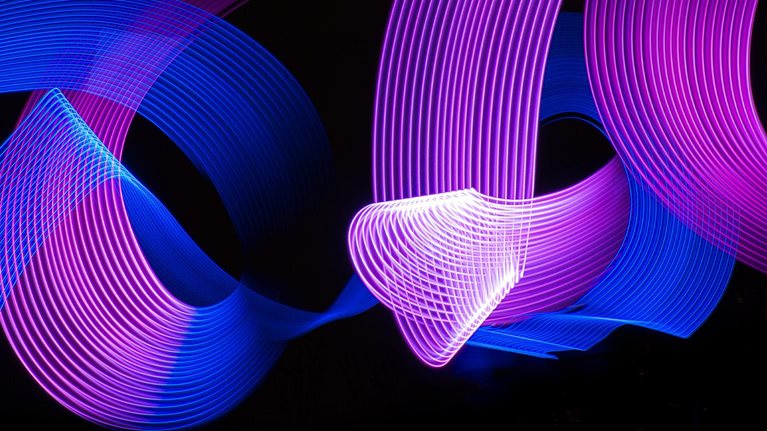 Conceptual blue and purple light lines painting swirling around and intersecting each other.