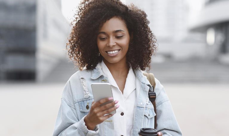 Young woman using smart phone on a city street