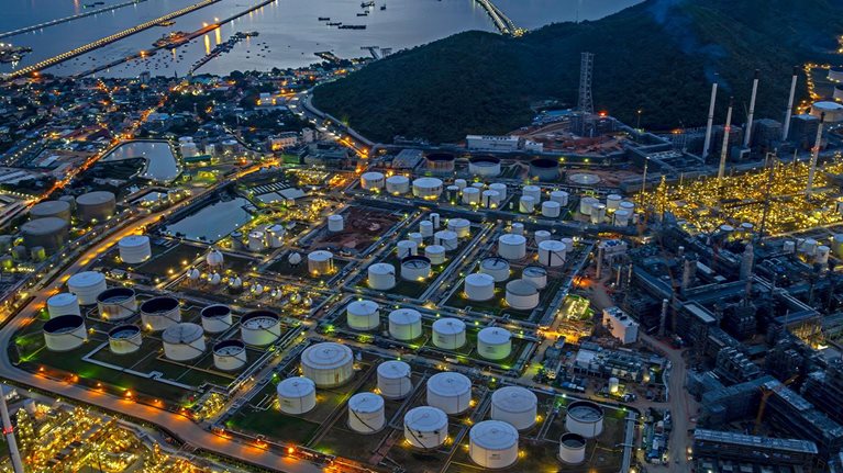 Aerial view oil refinery and fuel storage tanks at night time.