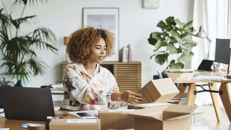 Female business professional analyzing packaging while sitting at table