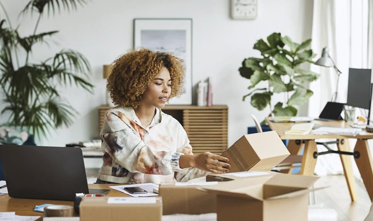 Female business professional analyzing packaging while sitting at table
