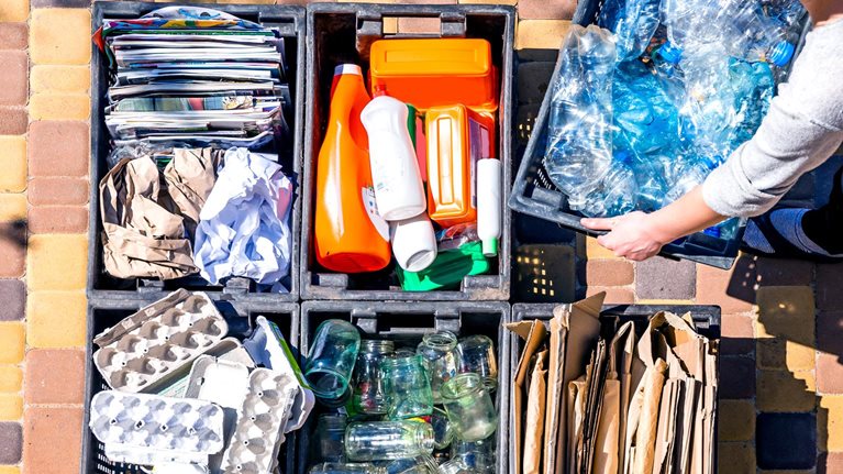 Woman organizes garbage containers for recycling