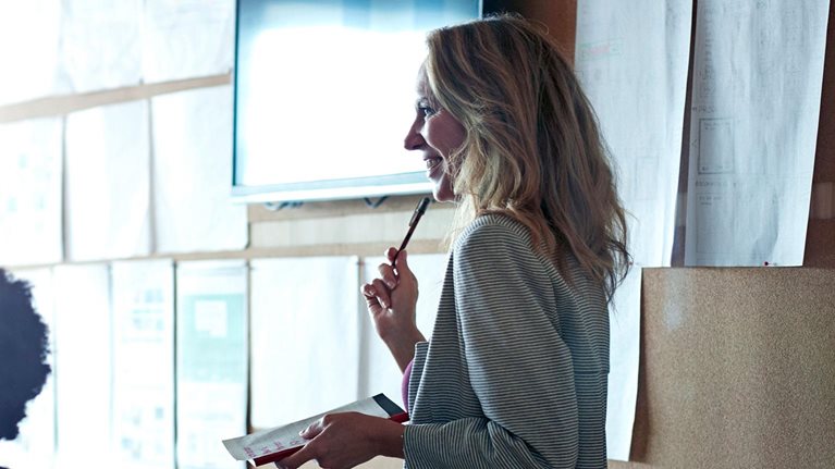 Woman doing presentation, using tablet & screen