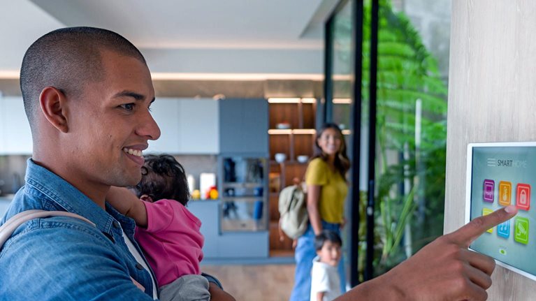 Happy Latin American family leaving a luxury apartment locking the door using a home automation system