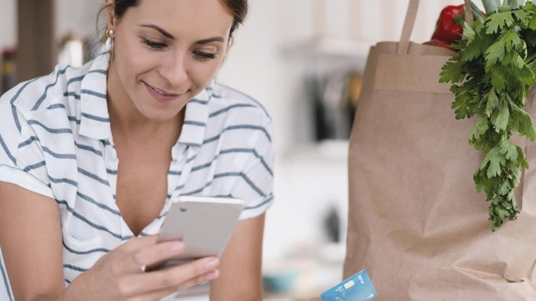 Woman at home paying online for a food delivery with a credit card