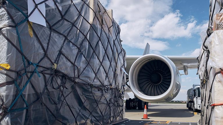 Preparation Before Flight. Loading Of Cargo Containers Against Jet Engine Of Freight Airplane.