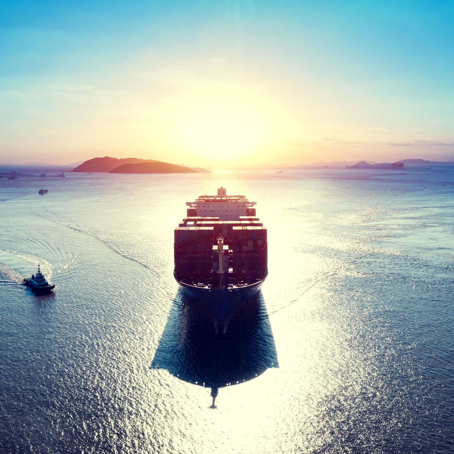 Cargo ship over sea at sunrise