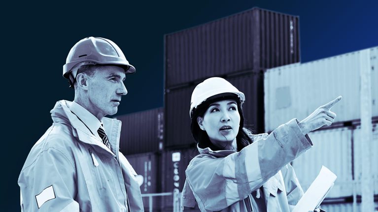 Two dock workers talking together while standing in a dockyard