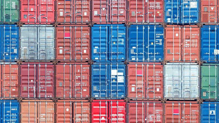 Stacked shipping containers filling the image from edge to edge.