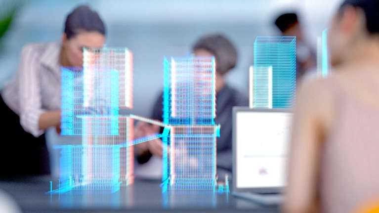 Engineers and architects working in a modern office with a building project visualized with augmented reality software.