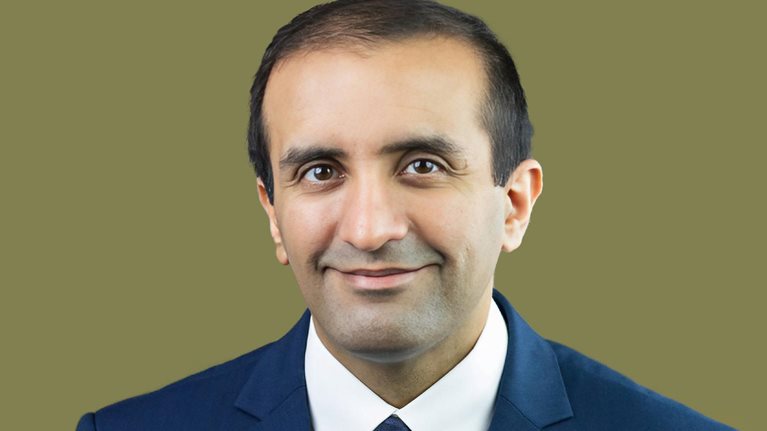 Portrait of Raj Panjabi with an easy smile and a blue suit.