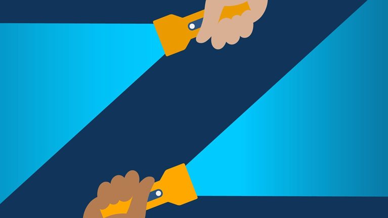 Two different hands, one on the bottom and one on the top edge of the image, each holding a lit flashlight. The negative space where the light beams don’t shine forms the letter “Z.”